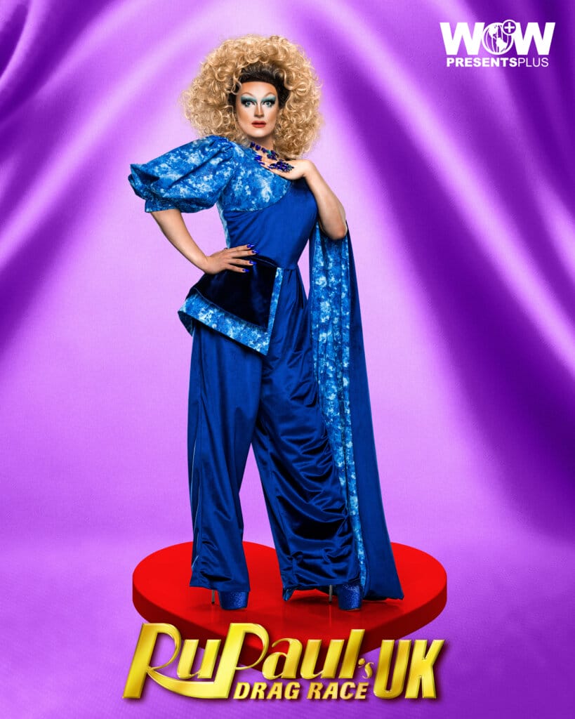 RuPaul's Drag Race UK Series 5: Another Front-Runner is Eliminated 18 Kate Butch posing for RuPaul's Drag Race UK series 5 promo for Meet The Queens in a blue outfit.