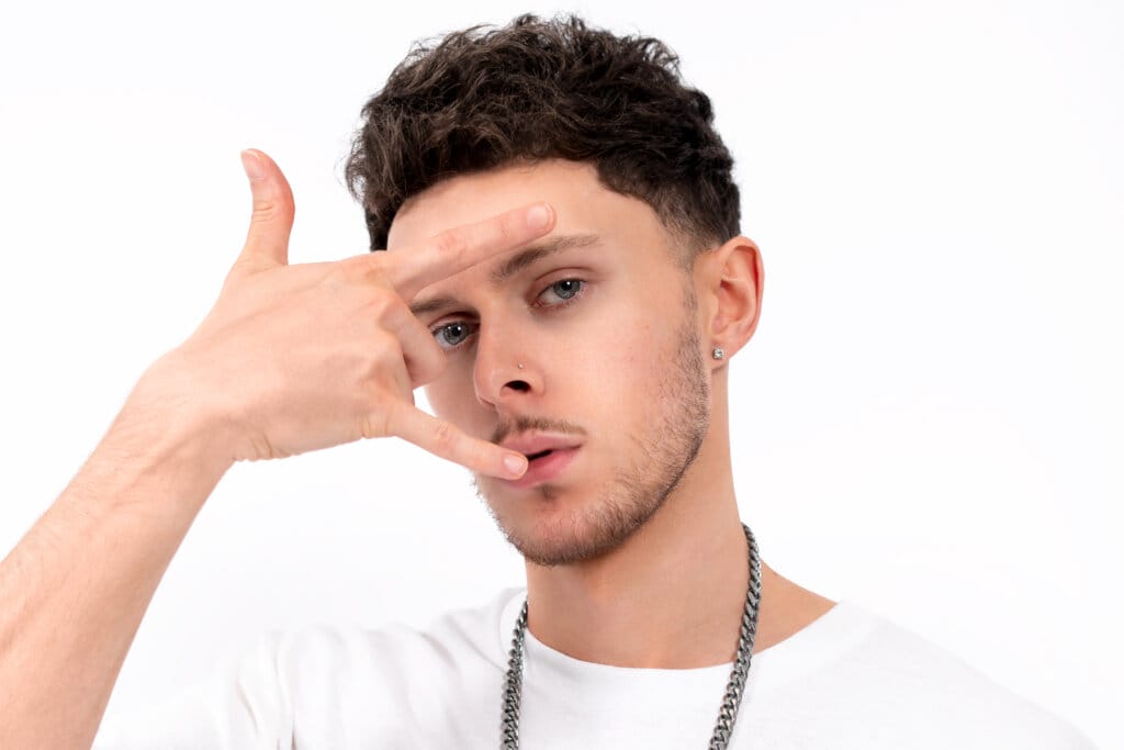 Close up of Scott the Pisces who has his hand in front of his face in a "rock on" sign.
