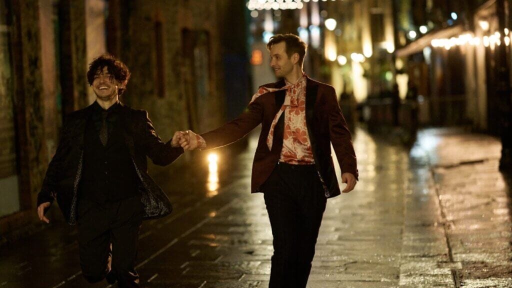 Still from "Lost Boys & Fairies" by the BBC, which sees Sion Daniel Young and Fra Fee holding hands in the street.