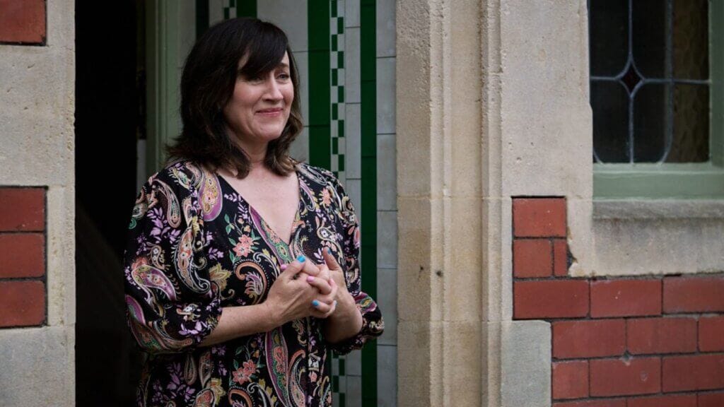 Still from "Lost Boys & Fairies" by the BBC which sees Marie Doyle Kennedy standing in a front doorway,