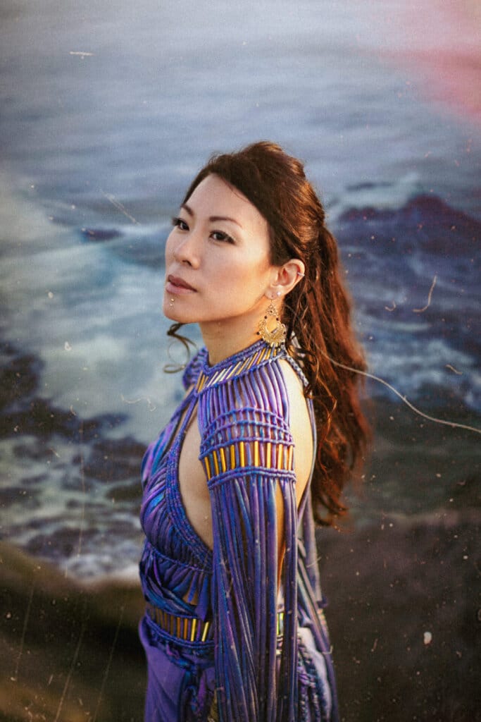 "Cobalt Sea": Eunice Keitan's Melodic South American and Southeast Asian Fusion 3 Promotional photo for "Cobalt Sea", which sees Eunice Keitan standing to the left with her head turned to the camera, wearing a blue dress that matches the sea behind her.