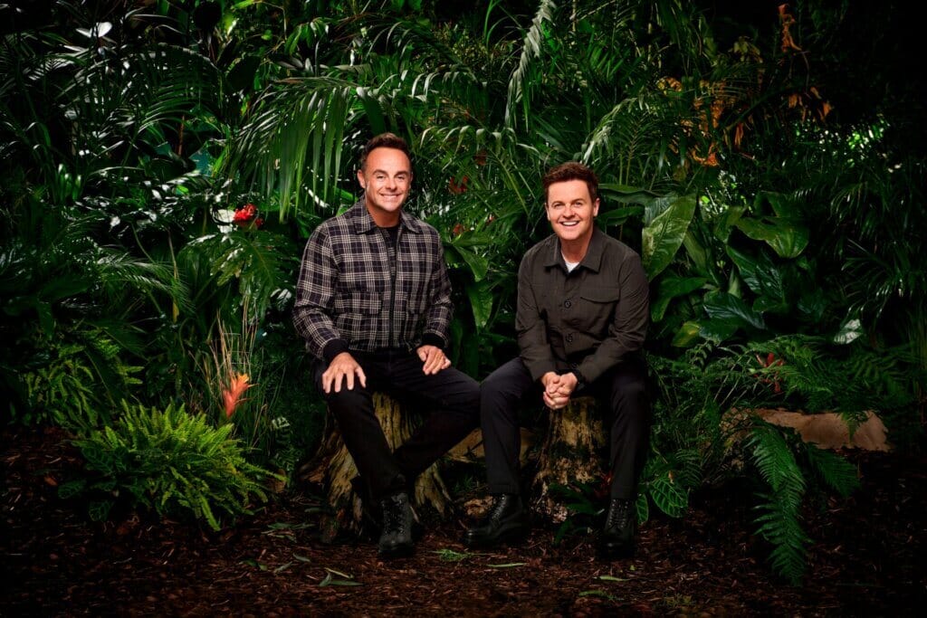 Famous Faces, Fearful Fates: I'm a Celebrity… Get Me Out of Here! 2023 Cast Has Been Revealed 58 Promotional photo for I'm a Celebrity… Get Me Out of Here! 2023, which sees Ant & Dec sitting in a jungle setting, wearing the camp uniform.