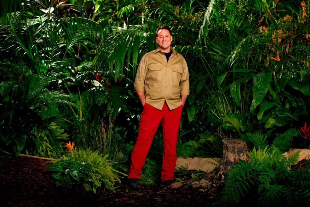 Famous Faces, Fearful Fates: I'm a Celebrity… Get Me Out of Here! 2023 Cast Has Been Revealed 64 Promotional photo for I'm A Celebrity... Get Me Out Of Here! 2023, which sees Nick Pickard in a jungle setting, wearing the camp uniform.