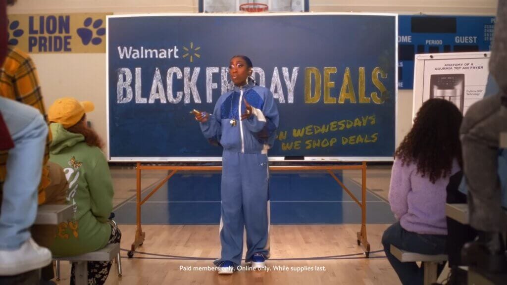 Walmart's Mean Girls Reunion with Lindsay Lohan, Amanda Seyfried, and Lacey Chabert: A Jaw-Dropping Fetch Black Friday Delight 6 Still from Walmart's Mean Girls reunion advert which sees Missy Elliott teaching in the gym about Black Friday deals at Walmart.