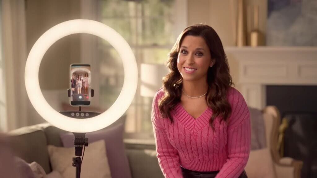 Walmart's Mean Girls Reunion with Lindsay Lohan, Amanda Seyfried, and Lacey Chabert: A Jaw-Dropping Fetch Black Friday Delight 10 Still from Walmart's Mean Girls reunion advert which sees Lacey Chabert standing next to a ring light as he daughter and friends record a Tiktok.