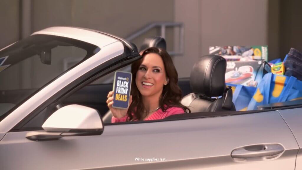 Walmart's Mean Girls Reunion with Lindsay Lohan, Amanda Seyfried, and Lacey Chabert: A Jaw-Dropping Fetch Black Friday Delight 3 Still from Walmart's Mean Girls reunion advert which sees Lacey Chabert driving a convertible car.