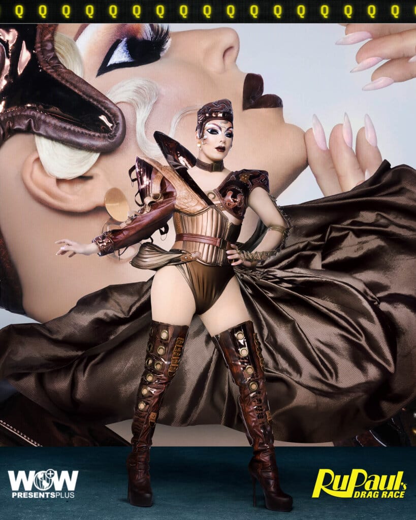 Q posing for RuPaul's Drag Race Season 16 promo for Meet The Queens in a copper outfit.