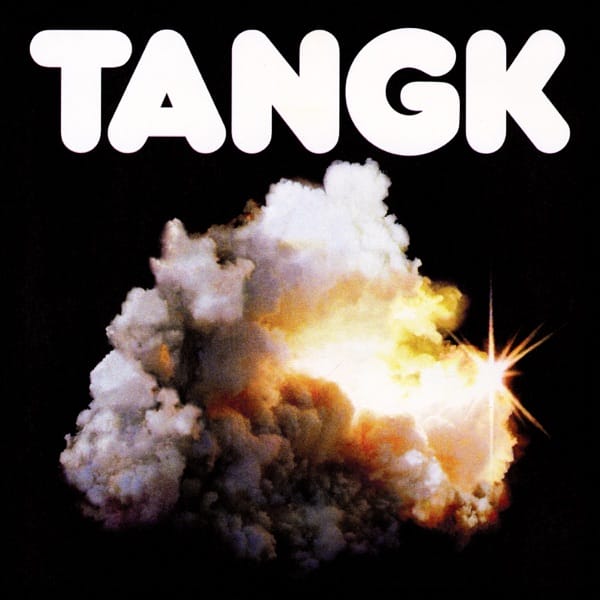 Official album artwork for IDLES' album "TANGK" which sees the album title at the top in big white lettering with an explosion of smoke as the image with a black background.