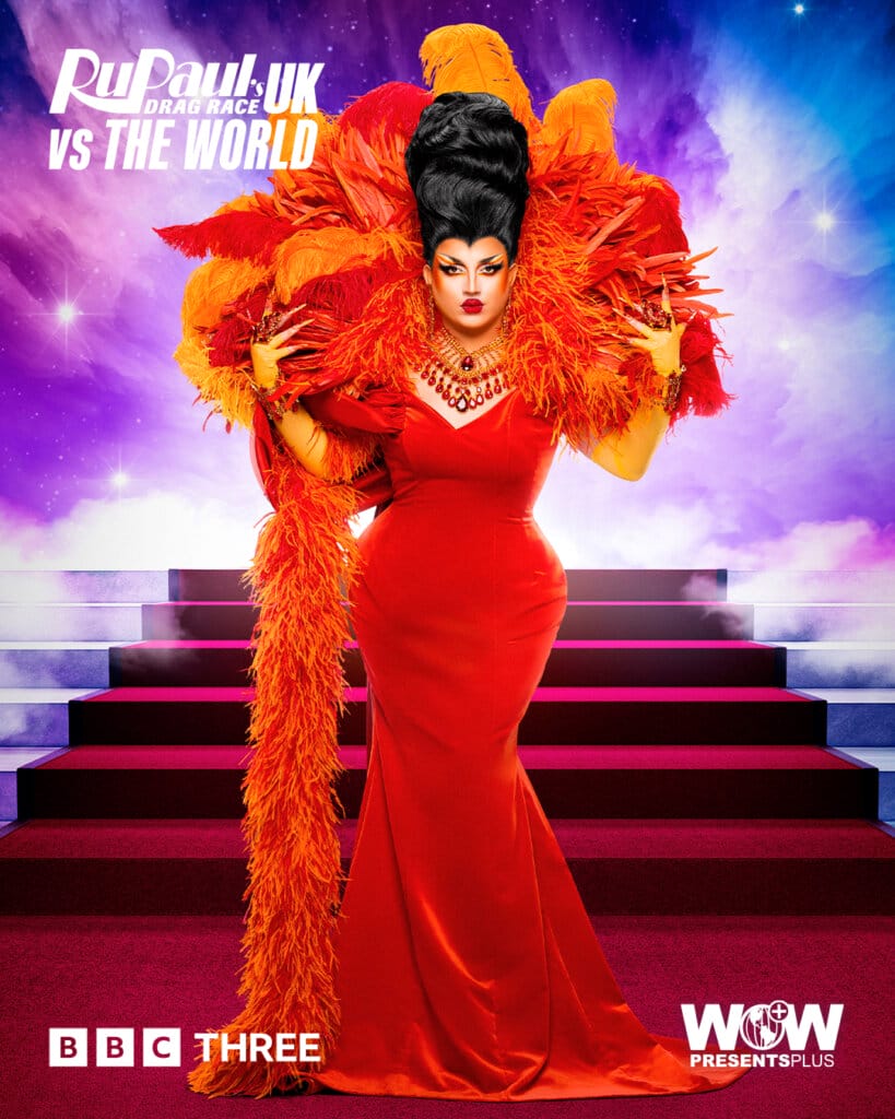 Slaying the World: Follow the Queens of RuPaul's Drag Race UK vs the World Series 2 91 Choriza May from RuPaul's Drag Race UK vs the World series 2, posing in an orange dress and feathered neck piece with a red carpet of stairs behind her.