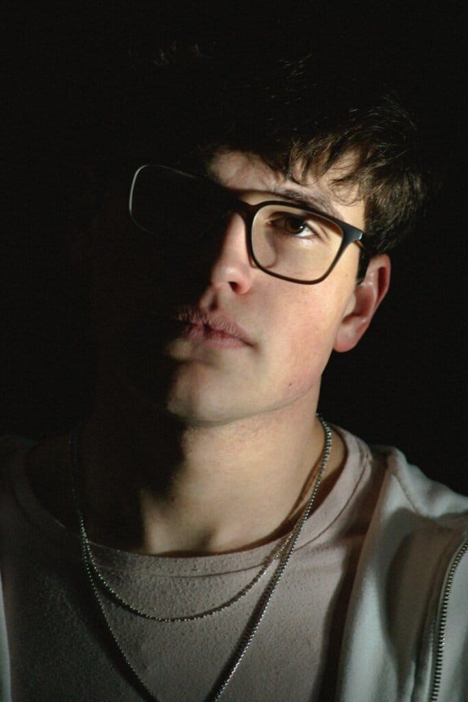 "Half of You": Delving into Emotional Turmoil Rob Eberle Releases Incredible Latest Single 11 Promotional image for "Half of You" which sees a head shot of Rob Eberle, wearing black-rimmed glassed, two chain necklaces and a sweater.