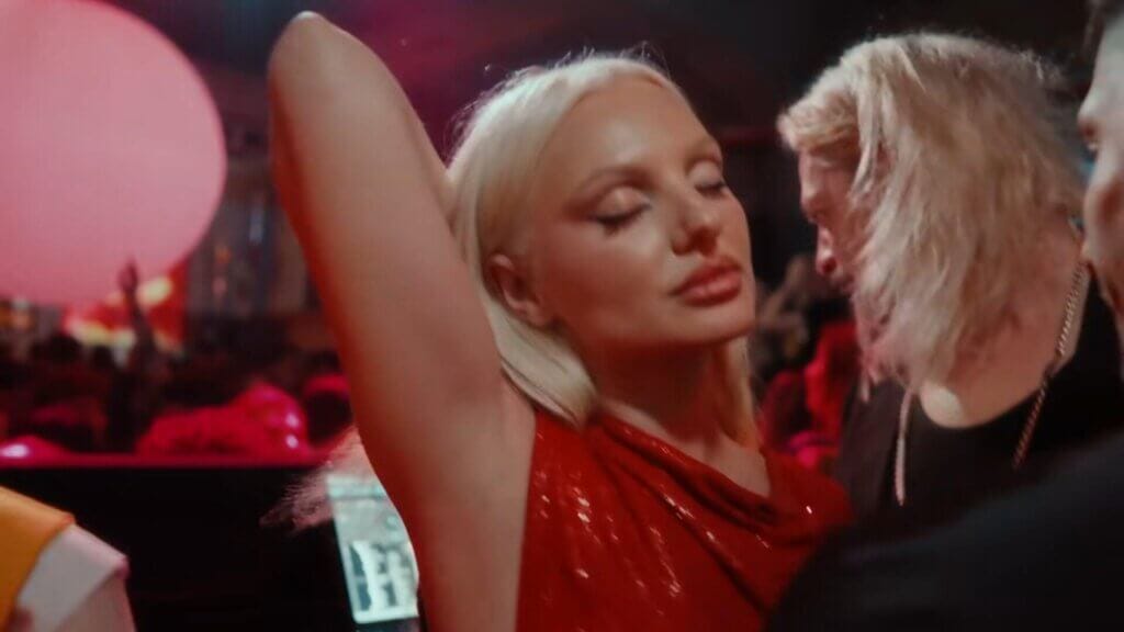 "Băieții" Music Video: Alexandra Stan Shines During Live Show at Apollo 111 for New Visual for Latest Song 19 Still from the "Băieții" music video which sees Alexandra Stan feeling herself at the DJ booth, dancing to music, with her eyes closed and one arm behind her head.