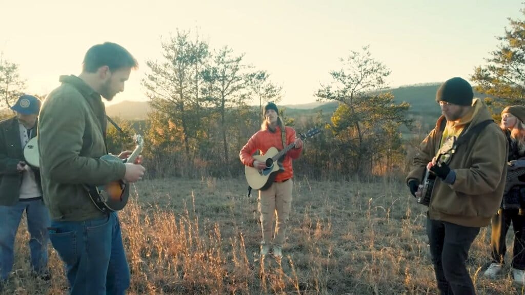 "Let Me Out": HAPPY LANDING's Entrancing Indie-Folk-Rock Single Echoes the Sentiments of Heartbreak and Healing 10 Still taken from the "Let Me Out" music video which sees the band HAPPY LANDING performing the song in a field, standing in a circle.
