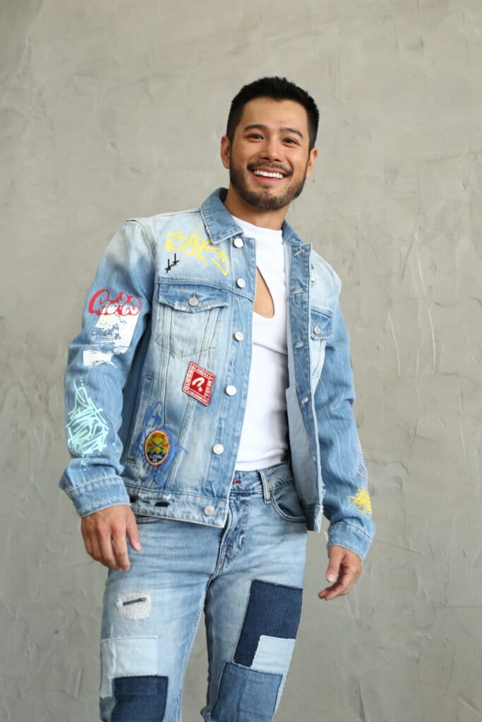 Wils Releases Final Single "Dancing Lights" Marking the End of a Musical Era 12 Full-length promotional photo for "Dancing Lights", which sees Wils smiling into the camera, wearing a blue denim jacket and a white t-shirt, with matching denim jeans.