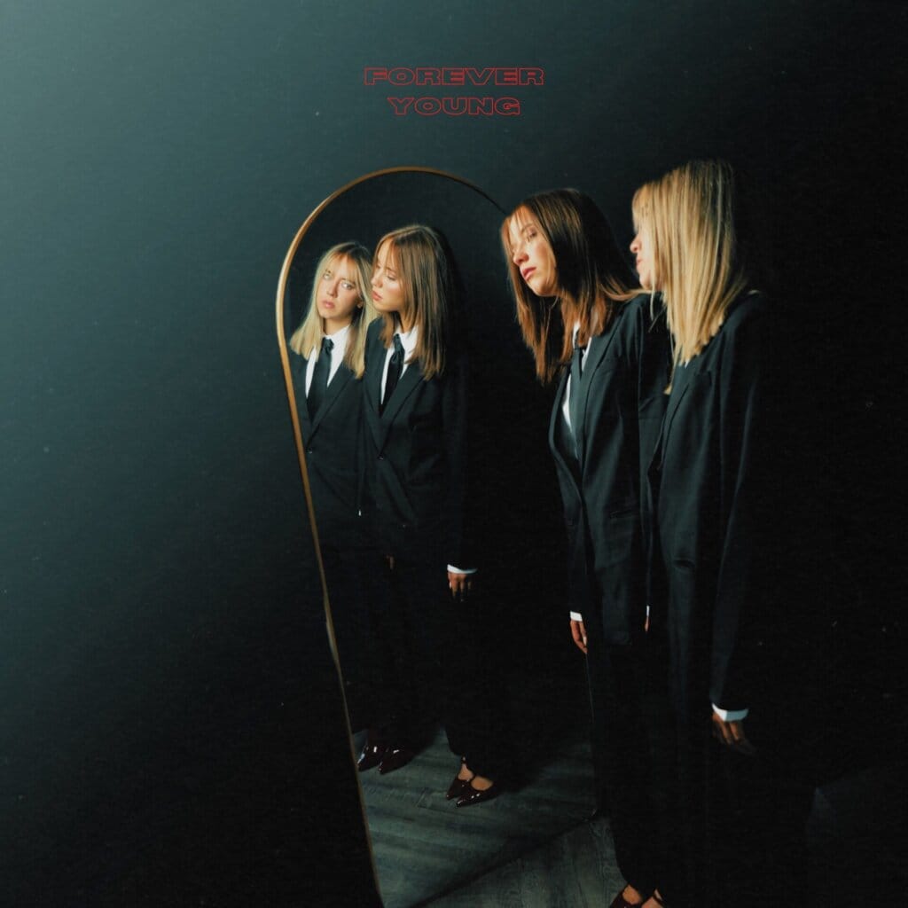 Single cover artwork for "Forever Young" which sees KTJ & Carly, dressed in suits, looking at themselves in a mirror.