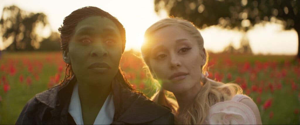 Elphaba and Glinda together showing their friendship as a poppy field is behind them.