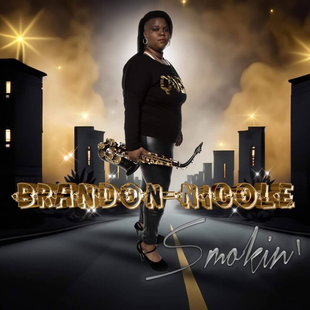 "Smokin'": Experience the Magic of Brandon-Nicole's Latest Single and Music Video Release 2 Official single cover artwork of "Smokin'" which sees Brandon-Nicole standing in the middle of a road with buildings staggered on either side, wearing black and holding a saxophone.