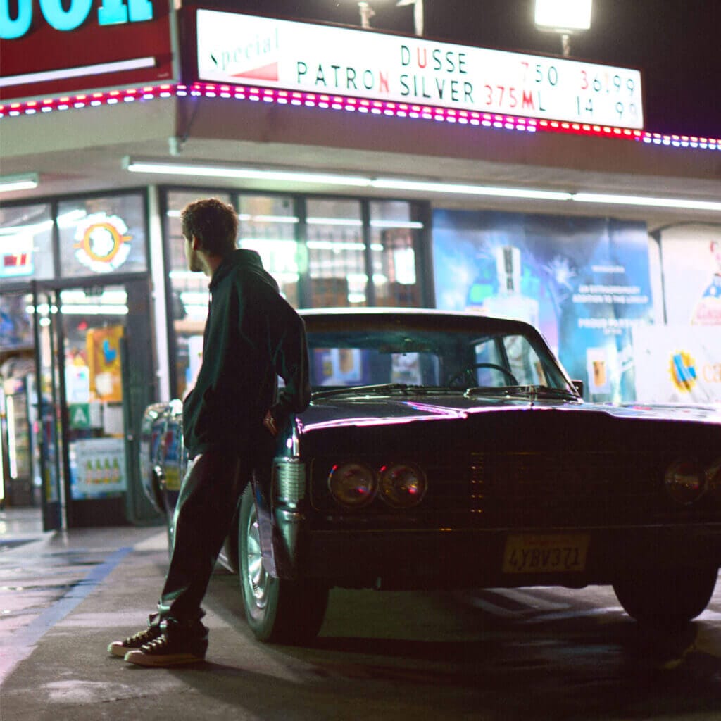 "Other People": The Heartfelt Journey of Loss and Reflection in Daniel Arison's New Single and Music Video 4 Official single cover artwork for "Other People" which sees Daniel Arison cast in shadow, leaning against a car in a mini market parking lot.