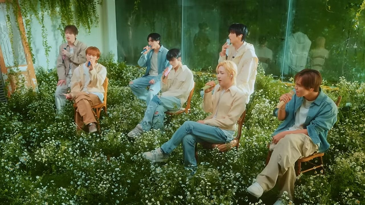 NCT Dream Releases Dreamy Live Performance Video for "Rains in Heaven" 26 Still from the live performance video of "Rains in Heaven" which sees the studio from the right corner, showing NCT Dream side-on as they perform in their chairs with a ground full of daisies.