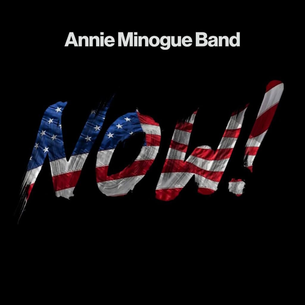 "NOW!": Annie Minogue Band Delivers Powerful Message in New Single 12 The official single cover artwork for "NOW!" which showcases the song's title on a black background which is cutout and made to look like the American flag is behind it, showing up where the song's title is.