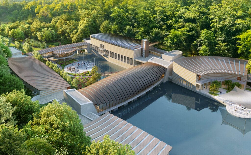 Crystal Bridges Museum Announces KAWS: FAMILY Exhibition for 2025 5 A closer shot of the north side of Crystal Bridges museum, showing more of the water and a flat open area.