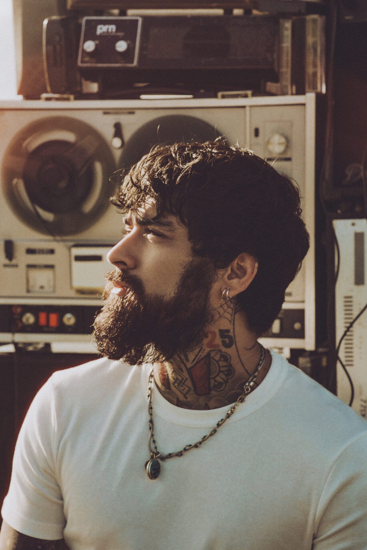 Stairway to the Sky Tour: ZAYN Expands His First-Ever Solo Tour With Additional Dates 30 Promotional photo for Stairway to the Sky Tour which shows ZAYB looking to the left, wearing a white t-shirt and a necklace, with a pile of speakers behind him.