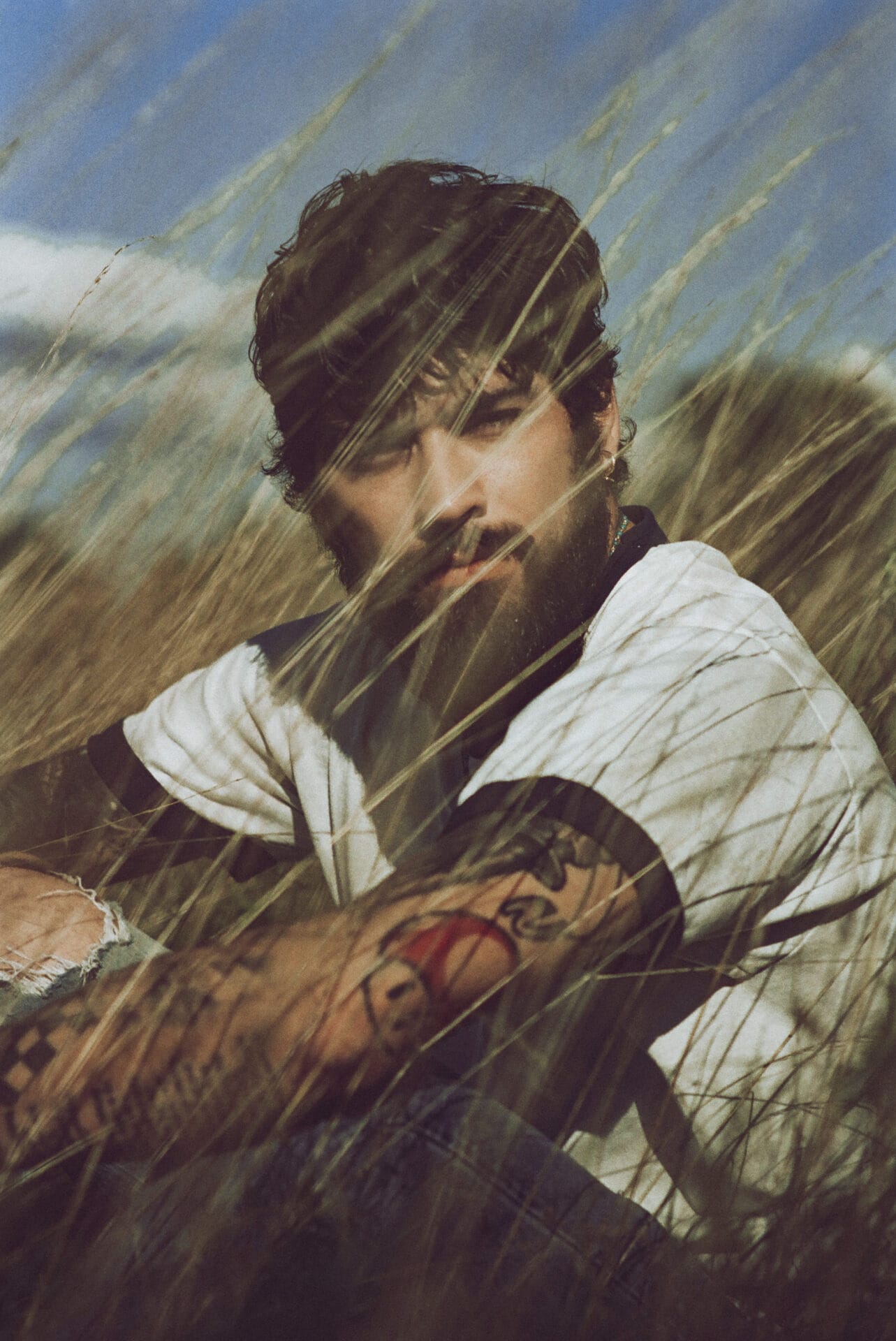 Stairway to the Sky Tour: ZAYN Expands His First-Ever Solo Tour With Additional Dates 26 Promotional photo for Stairway to the Sky Tour which shows a mid-shot of ZAYN sitting in the grass wearing a white t-shirt.