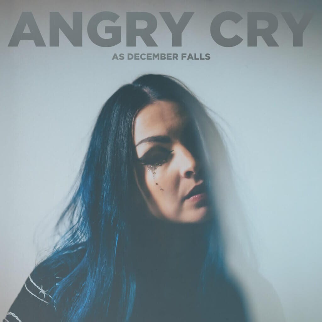 Official single cover artwork for "Angry Cry" which sees As December Falls' frontwoman Bethany Hunter crying with her blue hair misting into the light blue background.