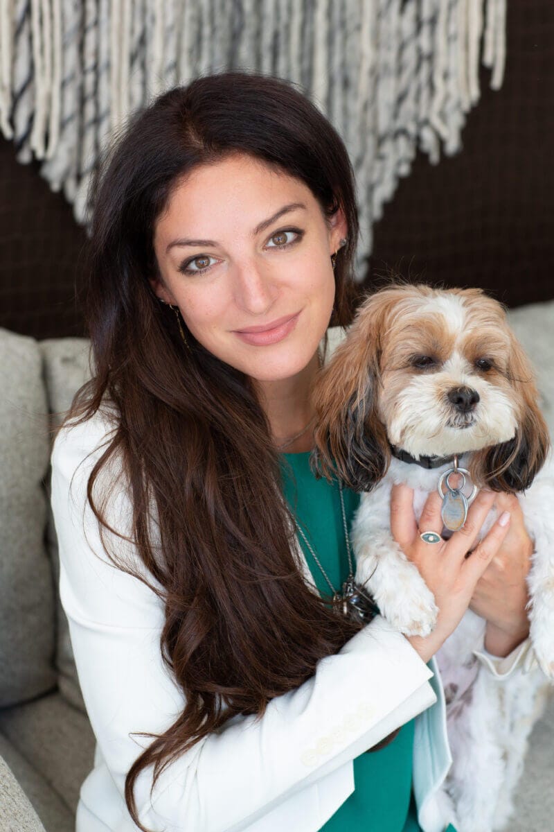 "Confessions of a Female Rabbi: Relevant Religion in an On-Demand World" by Rabbi Rebecca Keren Jablonski: An Inspiring Journey of Tradition and Transformation 10 Rabbi Rebecca Keren Jablonski wearing a white jacket and a green top, holding her dog to her chest.