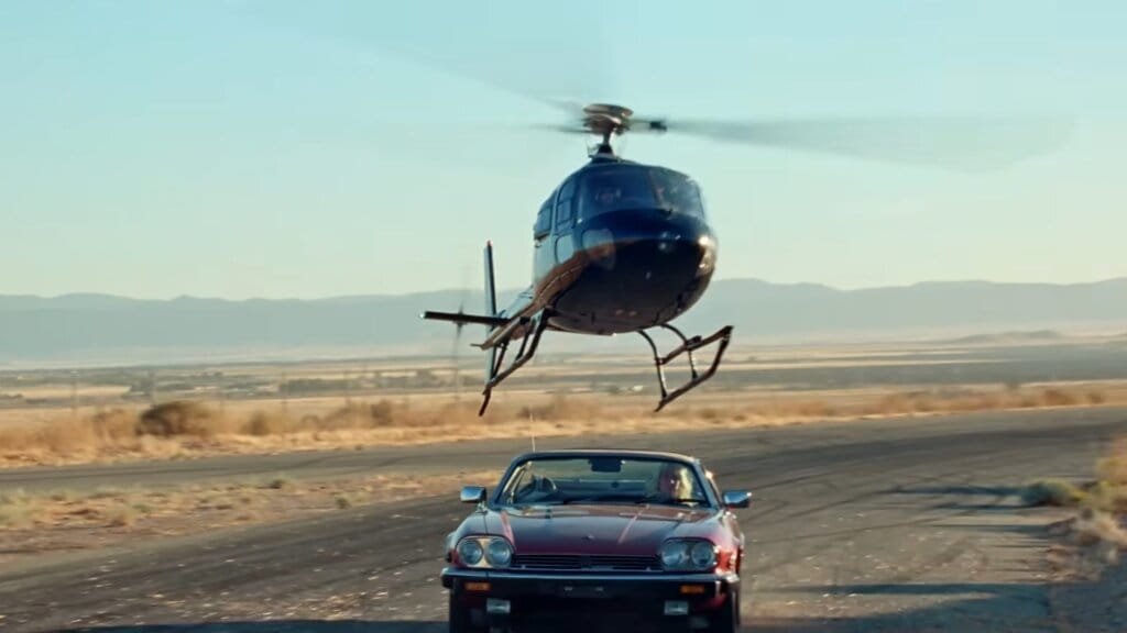 Still from the "Joyride" music video which sees Kesha driving a Jaguar convertible trying to escape from a helicopter that is right on her tail.