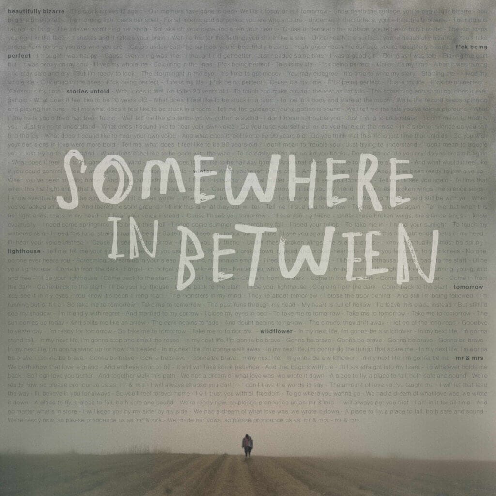 Somewhere in Between's "Stories Untold" Album Celebrates Love and Resilience Through an Indie-Folk-Pop Style 8 Official album cover artwork for "Stories Untold" which sees a lone silhouette of a person walking down a field with a huge grey sky above him that are filled with transparent lettering of the lyrics with the duo's name, "Somewhere In Between" written in strong off-white lettering.
