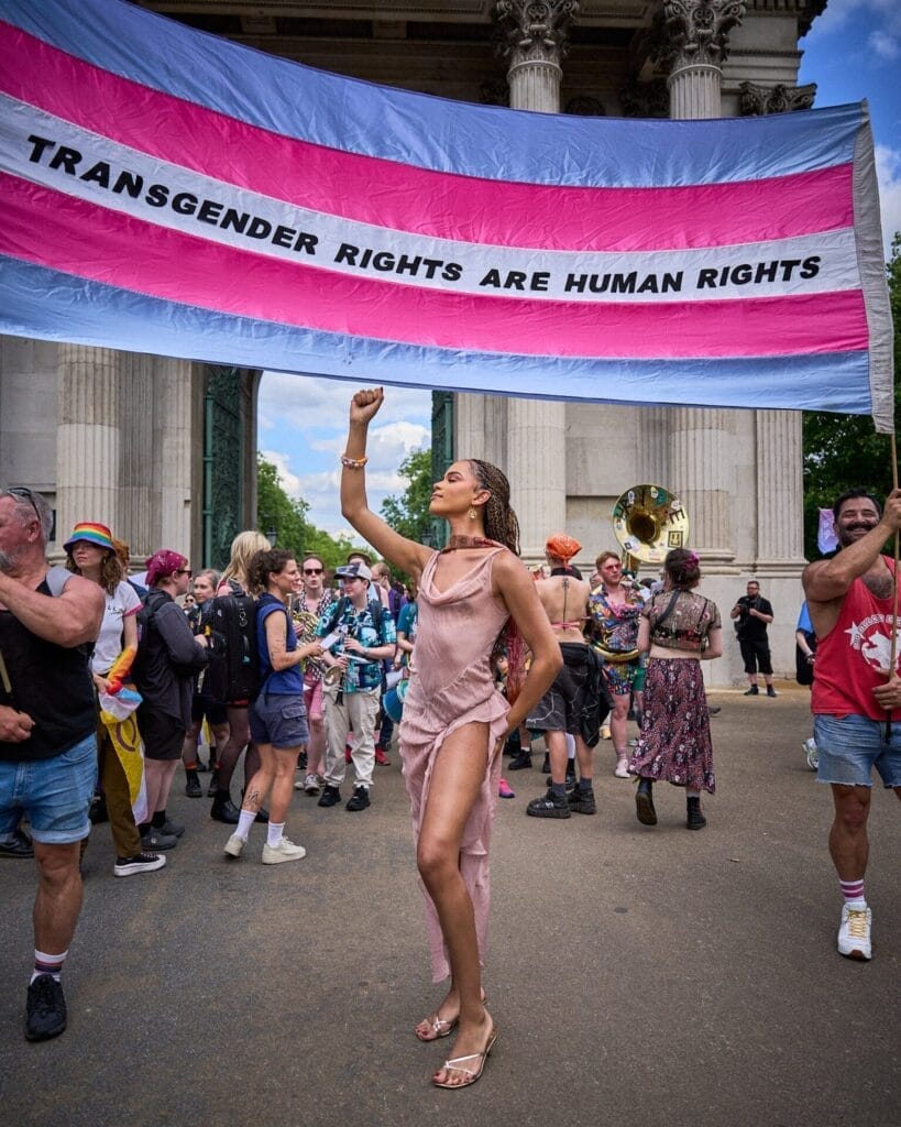 Yasmin Finney poses under a trans rights banner that says "Trans rights are human rights."