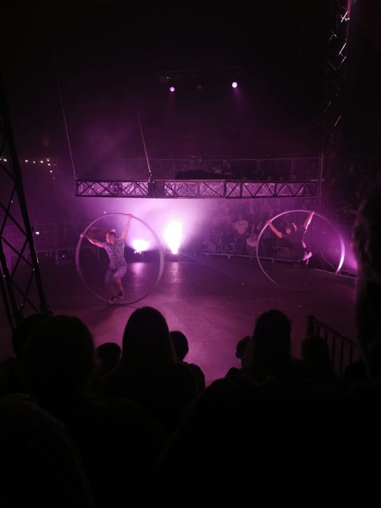 Another shot of the Cyr Wheel duo performing under the raised platform.