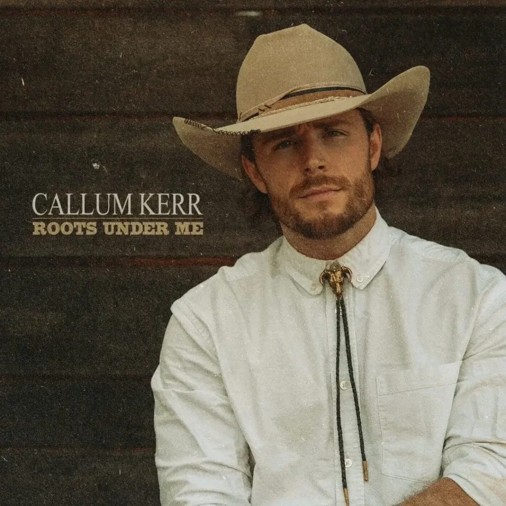 Callum Kerr Announces Debut EP "Roots Under Me" and Prepares for Grand Ole Opry Debut 8 Official EP artwork for "Roots Under Me" which sees Callum Kerr in a white shirt with bolo tie and a cowboy hat posing with his arms hanging in front of him, and backed against a wood panelling.