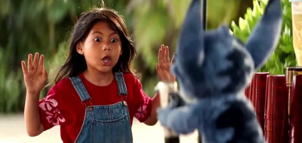 Film Review: Disney’s Lilo & Stitch (2025) Is a Nostalgic Journey That Will Make You Laugh, Cry, and Believe in ‘Ohana All Over Again 65 Lilo facing Stitch at the bar, with her hands in the air in surrender as Stitch points a drinks dispenser gun at her.