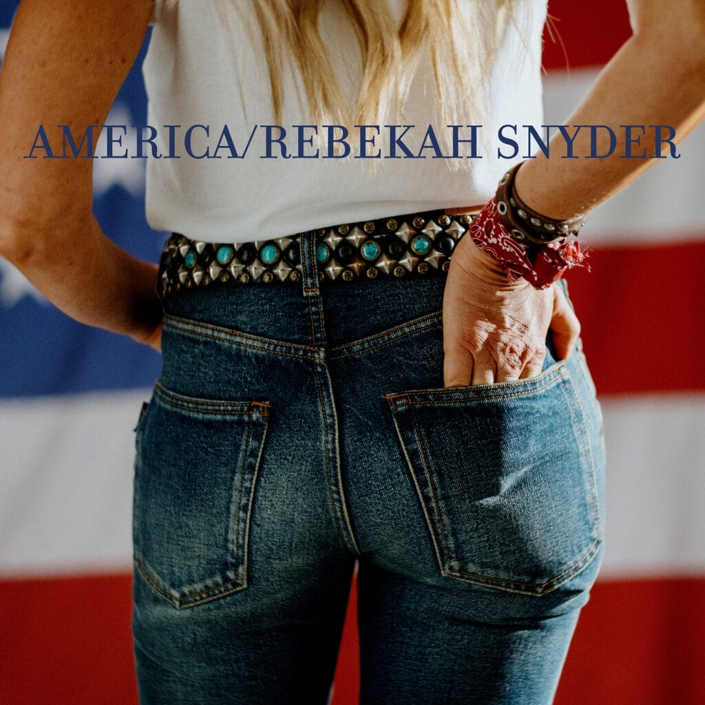 Rebekah Snyder Delivers Incredibly Powerful Acoustic Ballad with New Debut Single “America” 2 Official single cover for "America" by Rebekah Snyder, which sees a woman's butt in a pair of jeans and a white top. She is reaching into the back pocket of the pair of jeans.