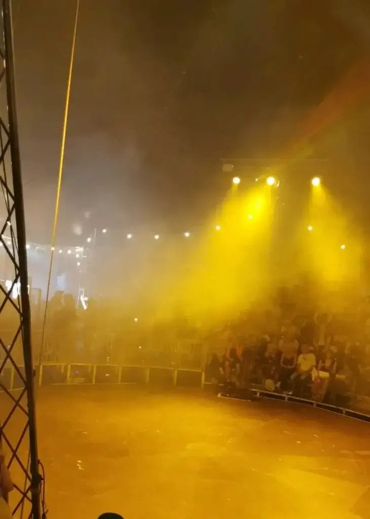 Inside the Big Top tent at Revel Puck Circus' The Circus Yard, with yellow lighting.