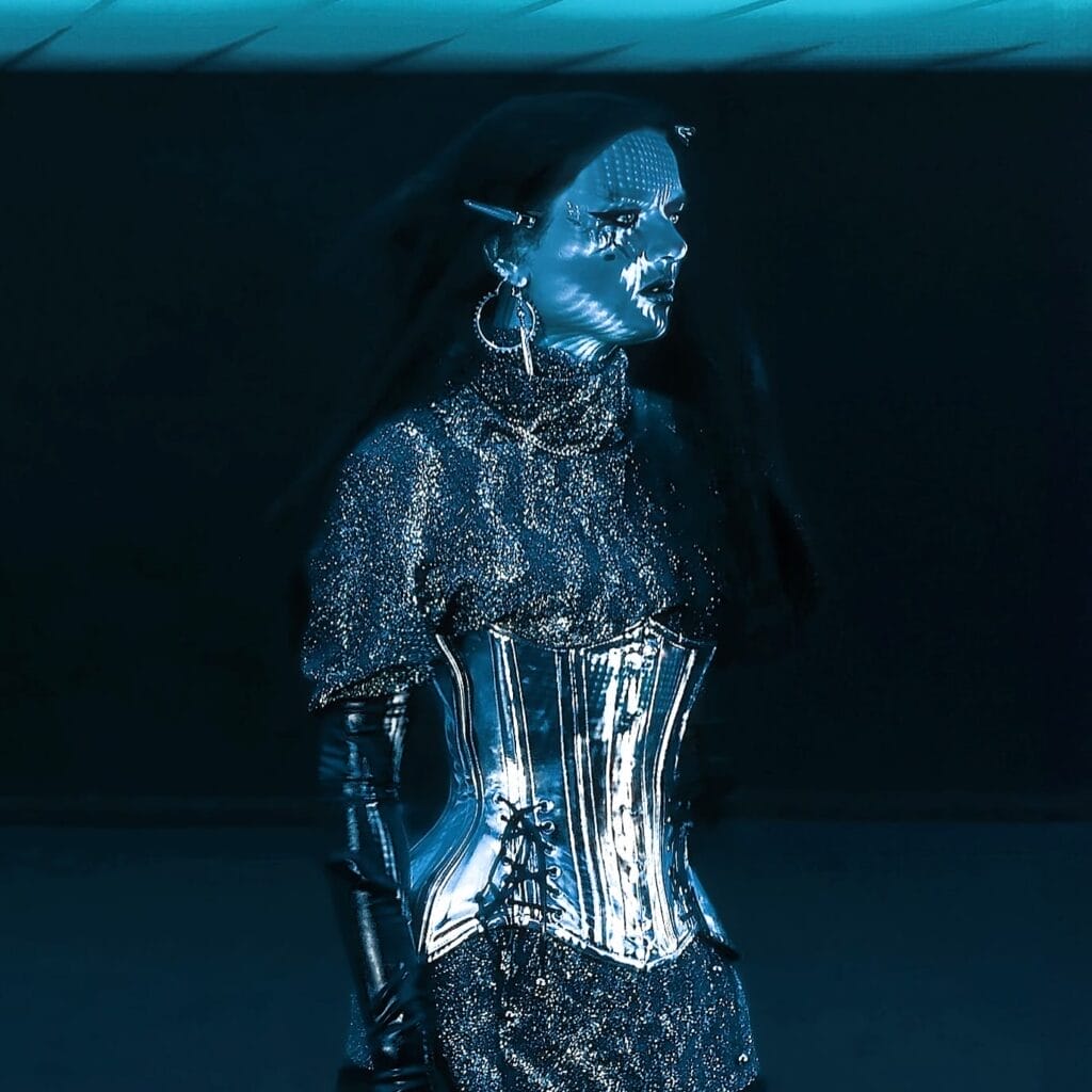 Still from the "SUPERNOVA" music video which shows Aurelia bathed in blue light, wearing a chromatic corset.