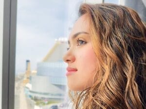 Side-shot of Camille K's face as she is looking out a window.
