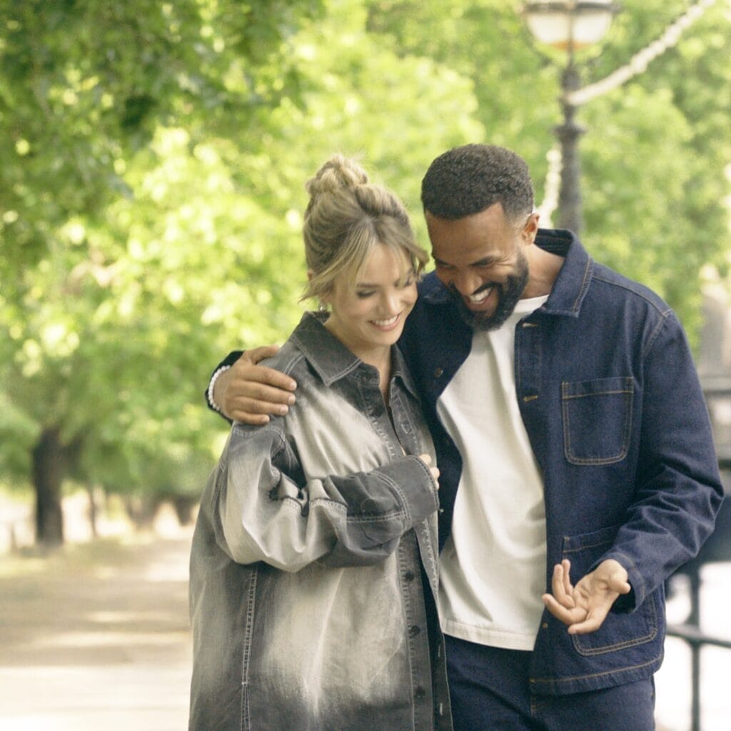 Official single cover artwork for "In It With You" which sees JoJo on the left and Craig David on the right who has his arm around her as they walk in a park.
