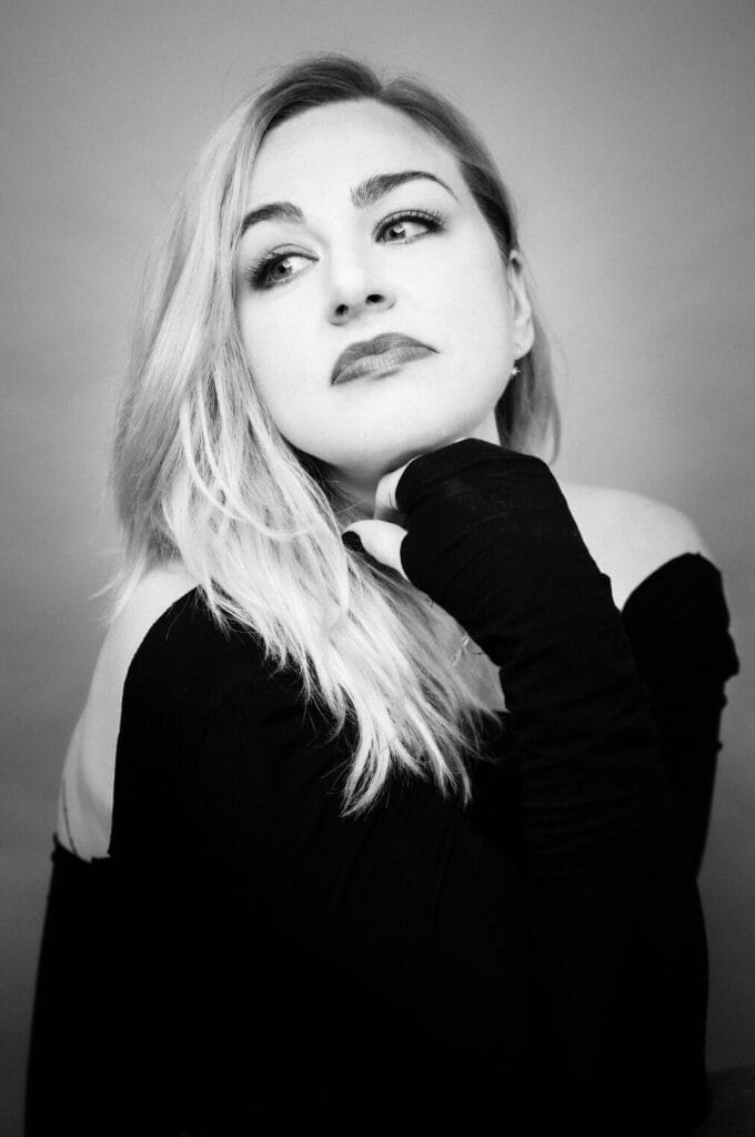 Official head shot photo of Bethany Watson which is in black and white and she's wearing a long-sleeve top.