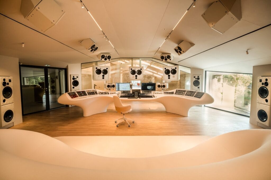 Inside the refurbished Miraval Studios which shows a high-tech studio layout with a cream colour-scheme and using the natural light from windows on the right to brighten the whole room.