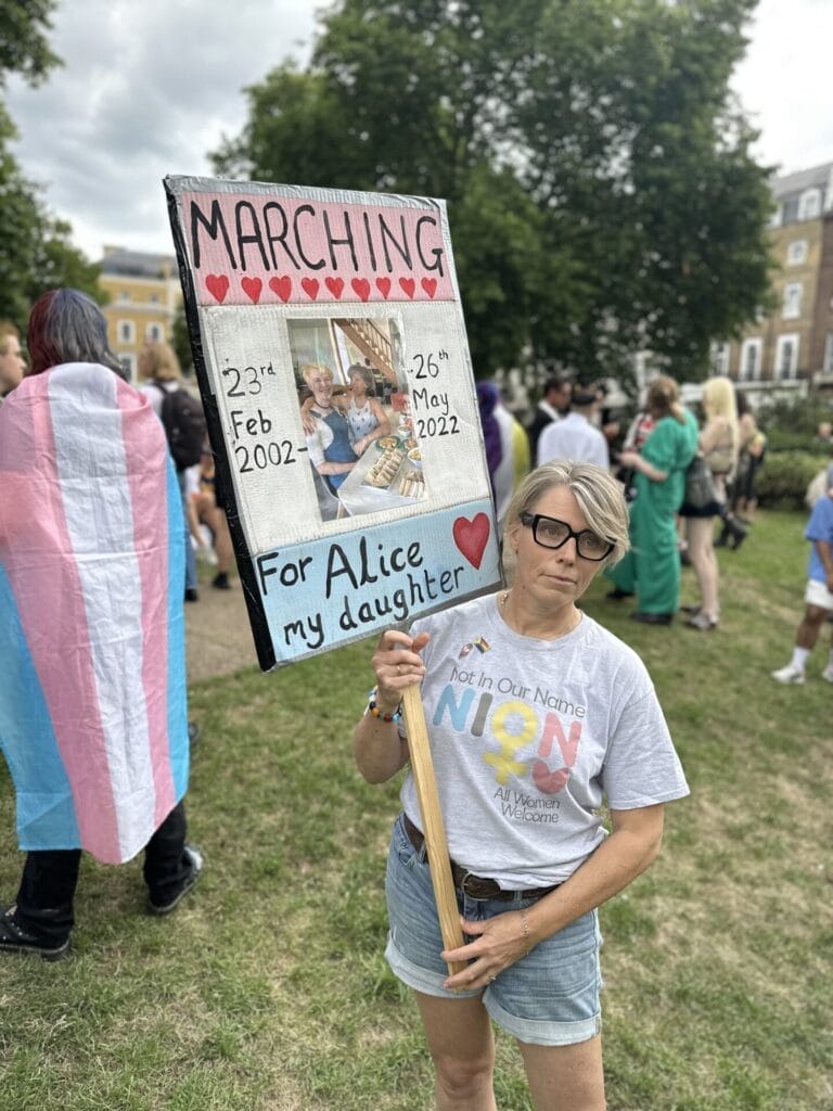 Caroline Litman holding up a sign that states she is marching for her daughter Alice.