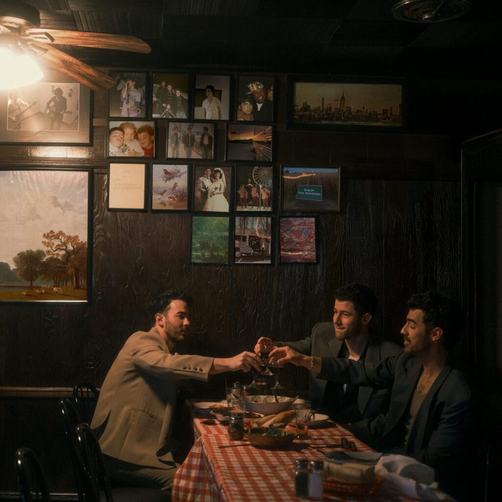 Official album artwork for "Greetings From Your Hometown" that is also used as the "I Can't Lose" single artwork, which sees the Jonas Brothers in a smalltown restaurant, chinking glasses.