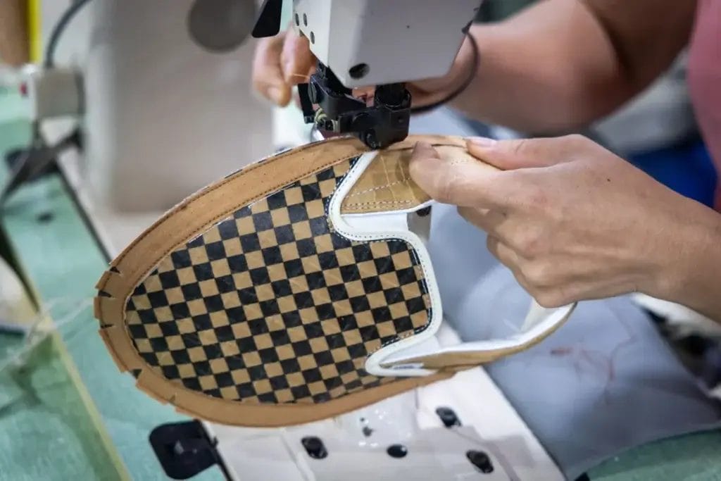 The making process of the Signal, Ernest Packaging, and Vans collaboration where cardboard is being sewn together with a sewing machine.