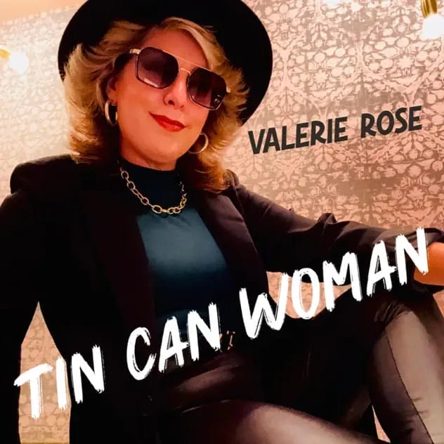 Valerie Rose Unleashes Soulful New Single “Tin Can Woman” Featuring Legendary Saxophonist Richie Cannata 10 Official single cover artwork for "Tin Can Woman" which sees Valerie Rose sitting on the floor leaning against a bright wall wearing a black jacket over a blue top, a gold chain necklace, a pair of shades, some black boots and a matching black hat.