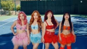 Still from the "I Bet You Never" music video where the four sisters from 4th Impact are posing on a blue tennis court, each wearing a mono-coloured outfit which is all styled similar.