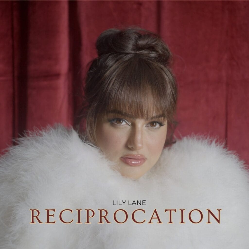 Official single cover artwork for "Reciprocation" which is a headshot of Lily Lane wearing a white fluffy fur coat in front of a red curtain, showcasing a stylish and sophisticated look.