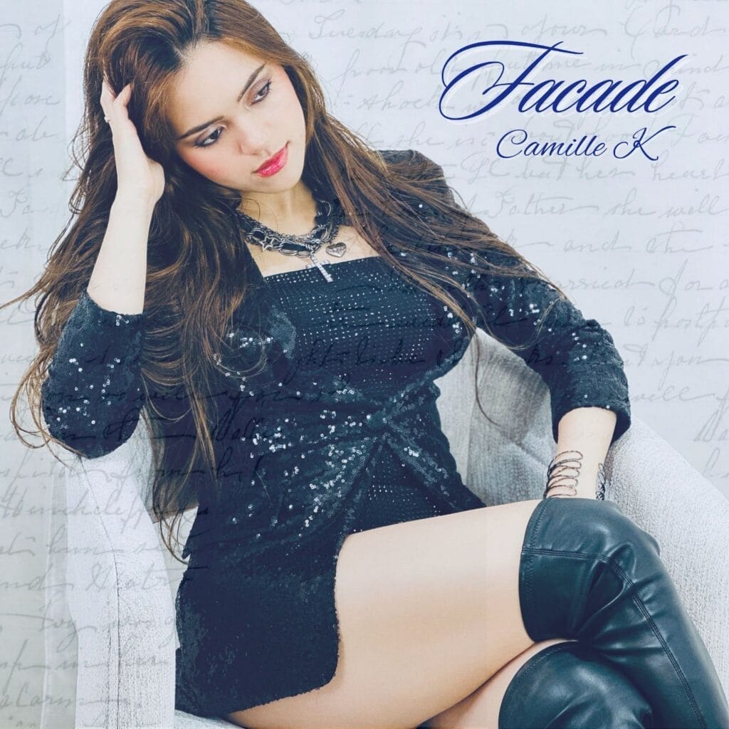 Official single cover artwork for "Facade" which shows Camille K sitting on a chair with her head resting on her right hand which is bent at her elbow. She's dressed in a black jacket, black top, and matching knee-high leather boots, looking sexy and confident.