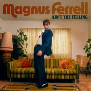 Official single cover artwork for "Ain't The Feeling" which shows a cool retro-themed cover art featuring Magnus Ferrell leaning back stylishly in front of a vintage green sofa, flanked by plants and a tall lamp. Warm, nostalgic tone.