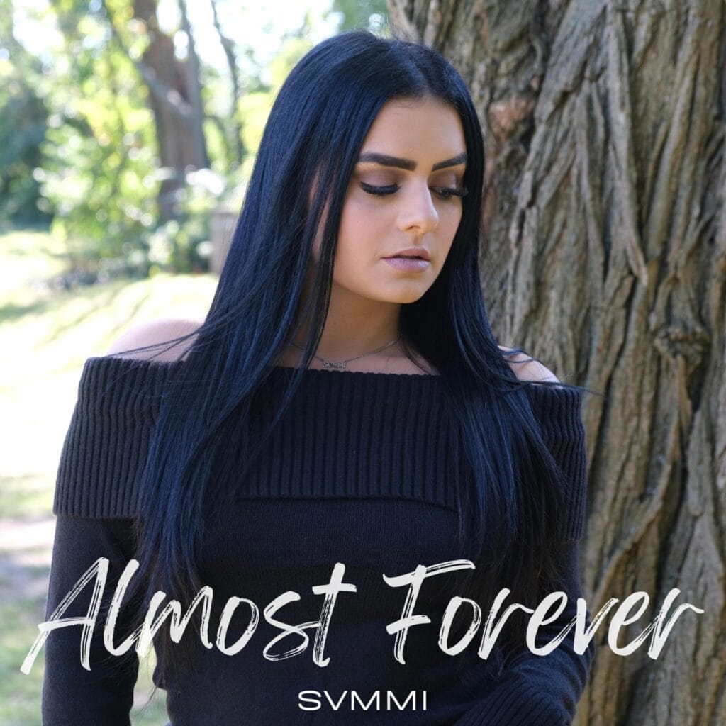 Official EP cover artwork for "Almost Forever" which shows SVMMI with long dark hair and an off-the-shoulder black sweater standing thoughtfully by a tree. Text overlay at the bottom reads "Almost Forever" with her name underneath.